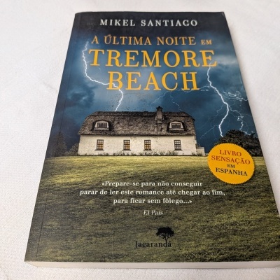 Capa do livro A Última Noite em Tremore Beach com casa e céu tempestuoso.
