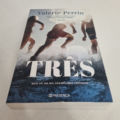 Livro TRÊS de Valérie Perrin com imagem de pessoas a correr na água e texto na capa.
