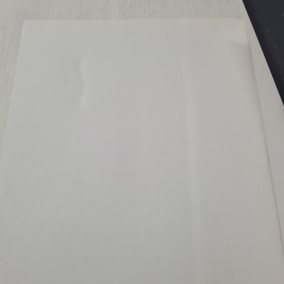 Folha de papel branco lisa sobre superfície clara com sombra ao lado