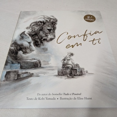 Capa de livro 'Confia em ti' com ilustração de leão e pessoa sentada.