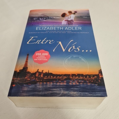 Capa do livro 'Entre Nós...' de Elizabeth Adler com imagem da Torre Eiffel ao pôr do sol