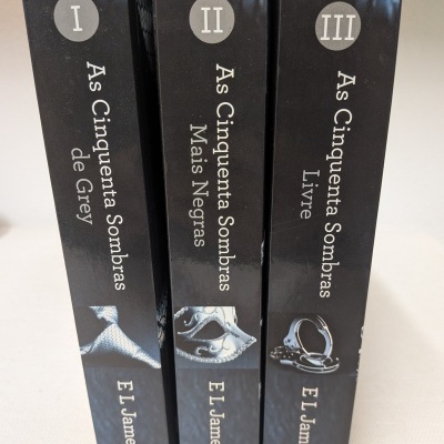 Três livros pretos da coleção 'As Cinquenta Sombras' de E L James