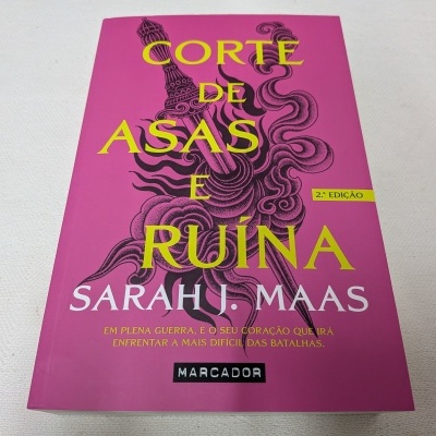 Livro 'Corte de Asas e Ruína' com capa rosa e texto amarelo