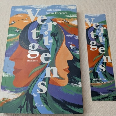 Livro e marcador de livro com capa colorida e arte abstrata de rostos na paisagem