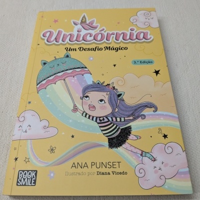 Capa de livro amarelo com ilustração de menina com guarda-chuva e arco-íris