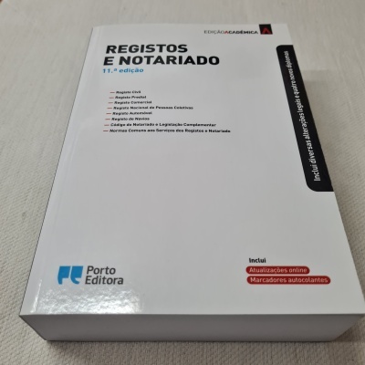 Livro REGISTOS E NOTARIADO com capa branca sobre superfície clara.