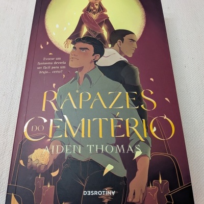 Capa do livro Rapazes do Cemitério de Aiden Thomas com ilustração de três personagens e fundo roxo.