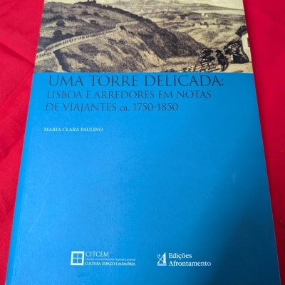 Livro azul com ilustração sepia e texto em português