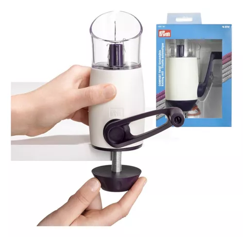 Moedor manual branco com manivela preta e depósito transparente fixado numa superfície com ventosa.