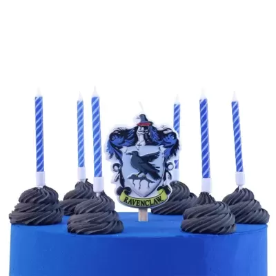 Bolo azul com velas azuis e brancas e decoração do brasão Ravenclaw.