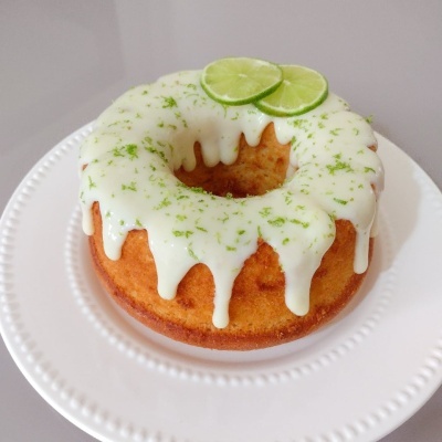 Bolo redondo com cobertura branca e rodelas de lima no topo