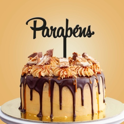 Bolo decorado com creme castanho e chocolate com topper 'Parabéns'