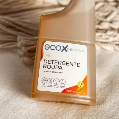 Frasco de detergente para roupa EcoXperience sobre superfície macia bege