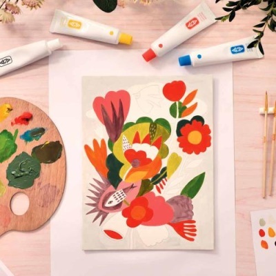 Tela com pintura floral abstrata e materiais de pintura sobre mesa de madeira clara