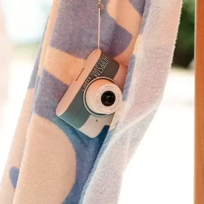 Câmara instantânea Fujifilm Instax Mini 11 pendurada numa toalha colorida