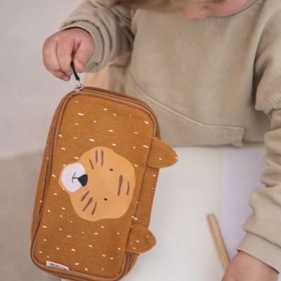 Estojo castanho com rosto de tigre e zip, criança segurando lápis de cor na mesa