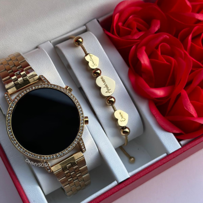 Relógio dourado com pulseira de metal e pulseira com corações gravados numa caixa decorada com rosas vermelhas