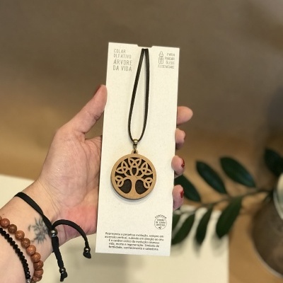 Colar difusor Árvore da Vida em madeira com cordão preto em cartão branco.