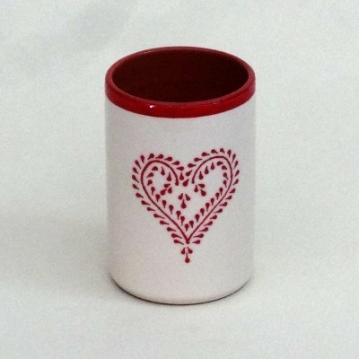 Recipiente cilíndrico branco com interior vermelho e padrão de coração vermelho.