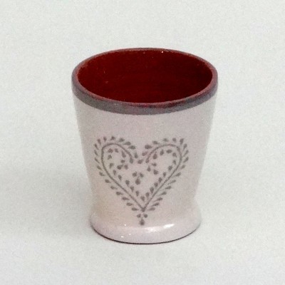 Copo pequeno de cerâmica branco com padrão de coração cinza e interior vermelho