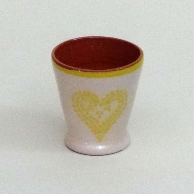 Copo pequeno de cerâmica branca com coração amarelo e interior vermelho