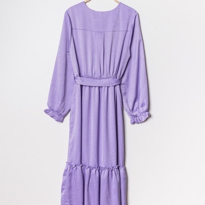 Vestido lilás comprido com mangas longas e cinto, pendurado numa cabide de madeira