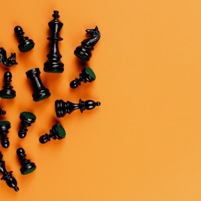 Peças de xadrez pretas sobre fundo laranja