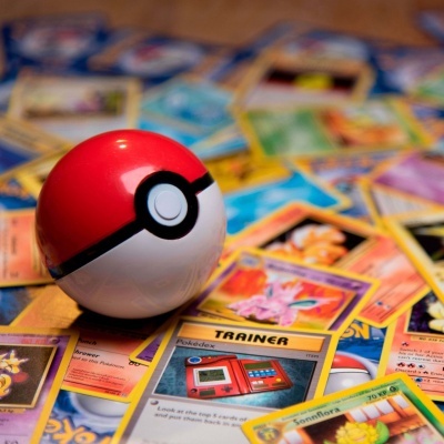Pokébola vermelha e branca sobre cartas Pokémon coloridas