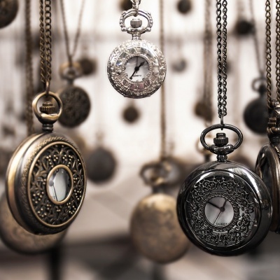 Relógios de bolso pendurados com caixas metálicas trabalhadas e mostradores visíveis