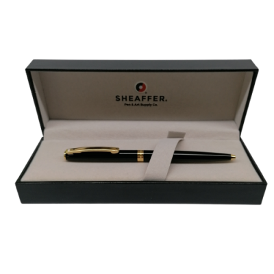 Caneta preta com detalhes dourados numa caixa preta forrada a tecido bege