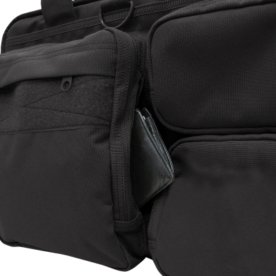 Mochila preta com vários compartimentos e carteira preta visível num bolso lateral