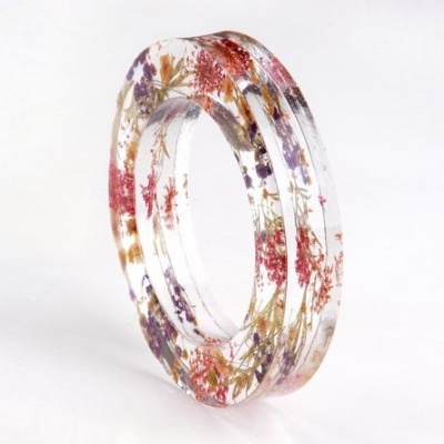 Pulseira transparente com flores secas coloridas dentro.