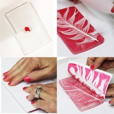 Processo de moldagem com base transparente, tinta vermelha, pena branca e molde rosa.