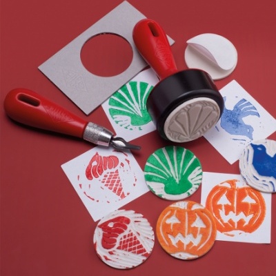 Carimbos e ferramentas para cortar papel com desenhos coloridos em fundo vermelho