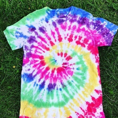 T-shirt tie-dye colorida em espiral sobre relva