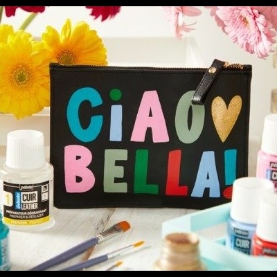 Estojo preto colorido com texto 'CIAO BELLA!' e tubos de tinta com pincéis e flores