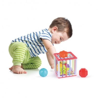 Criança a brincar com brinquedo de formas geométricas coloridas.