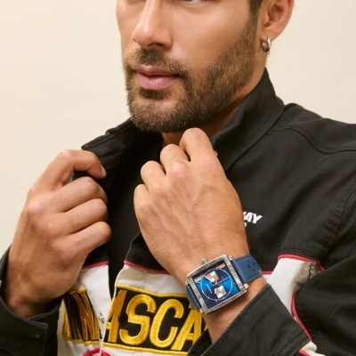 Relógio masculino azul com pulseira de couro e camisa preta com texto amarelo