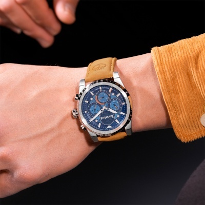 Relógio de pulso azul com bracelete de pele castanha no pulso