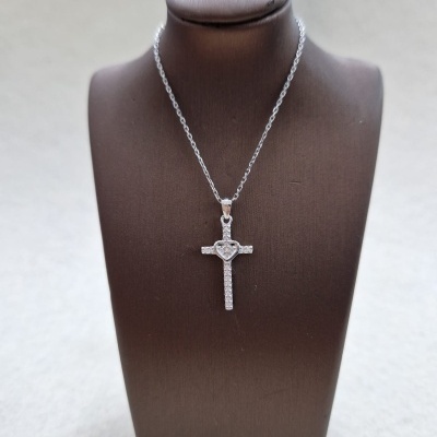 Colar com pendente de cruz prateada com pedras brilhantes em suporte castanho