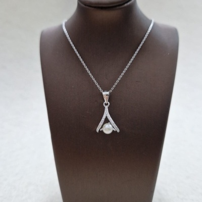 Colar prateado com pérola pendurado em busto castanho