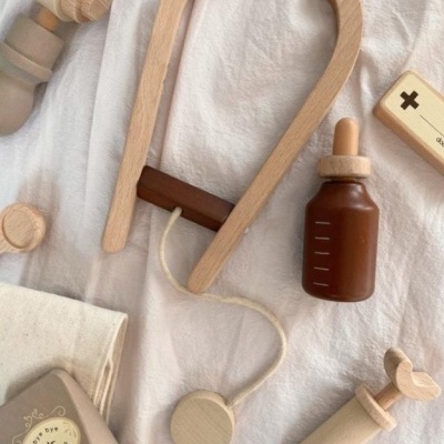 Brinquedos médicos de madeira sobre tecido branco e bege