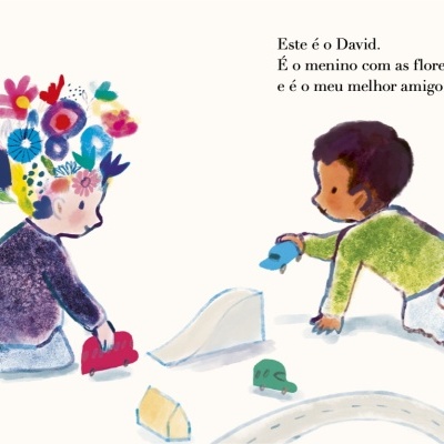 Duas crianças a brincar com carros de brinquedo, uma com flores no cabelo e texto em português