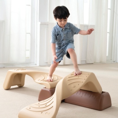 Brinquedo infantil de equilíbrio bege e castanho e menino em casa