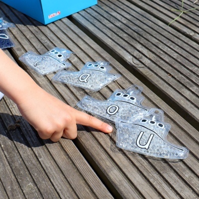 Peixes transparentes com letras para aprendizagem sobre piso de madeira