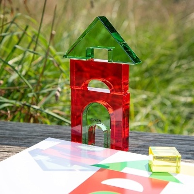 Blocos de construção translúcidos coloridos em papel sobre superfície de madeira ao ar livre