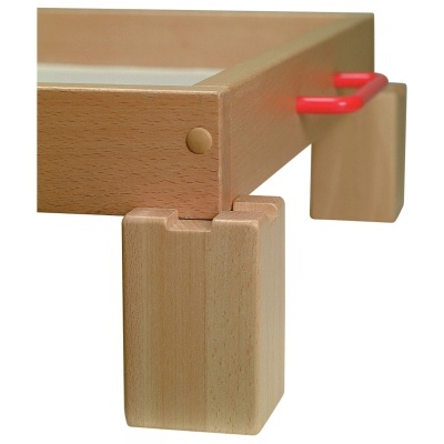 Mesa de madeira clara com pernas grossas e vidro no tampo com punhos vermelhos