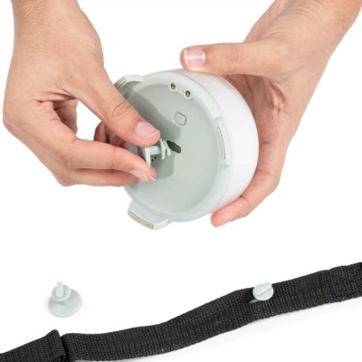 Dispositivo circular branco com mecanismo e tira preta com botão