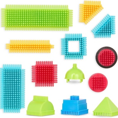 Peças plásticas coloridas com texturas diversas em fundo branco