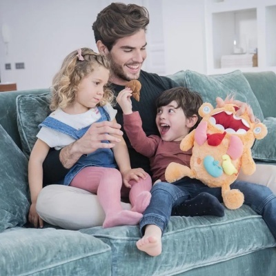 Homem com crianças no sofá segurando boneca de pelúcia colorida
